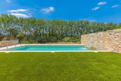 a swimming pool in a yard with green grass at Flateli Diana in Sant Jordi Desvalls