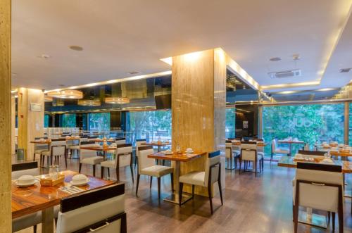 a restaurant with wooden tables and chairs and large windows at TURIM Av. Liberdade Hotel in Lisbon