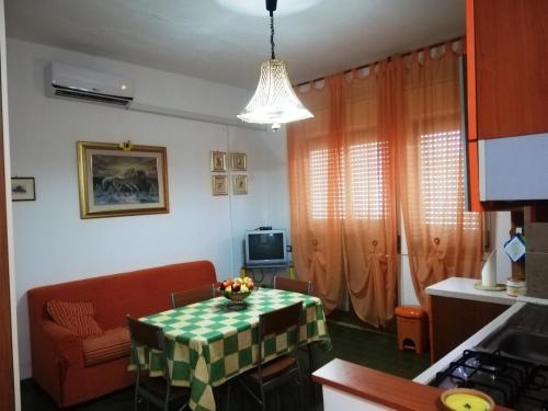 Una cocina con una mesa y un sofá en una habitación. en Appartamento Ginepri, en Lamezia Terme