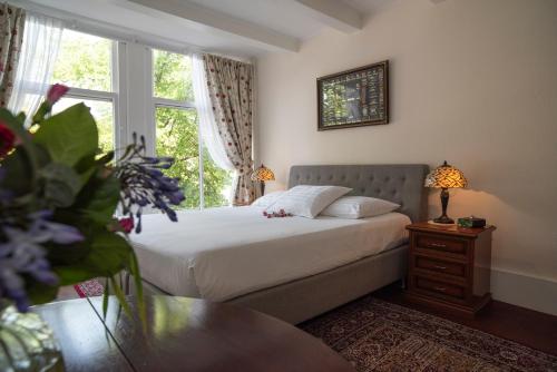 a bedroom with a bed with a window and a table at Keizershouse Amsterdam in Amsterdam