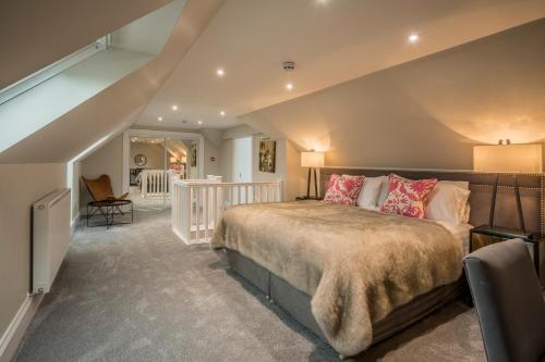 een slaapkamer met een groot bed en een trap bij Carlogie House in Carnoustie