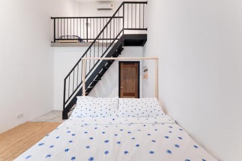 a bed in a room with a staircase at The Rubber Escape, Melaka in Melaka
