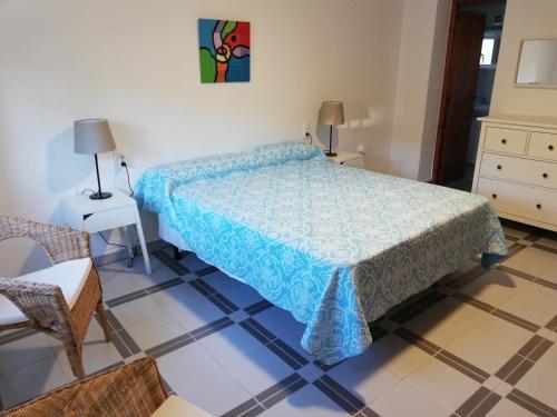 a bedroom with a bed and a chair and a table at Adel Locdenia in Els Poblets