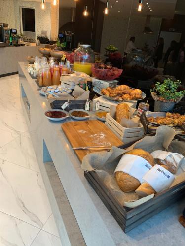 um buffet de pão e outros alimentos sobre uma mesa em Radisson Blu Hotel, Port Elizabeth em Port Elizabeth