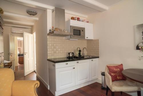 a kitchen with white cabinets and a counter top at Keizershouse Amsterdam in Amsterdam