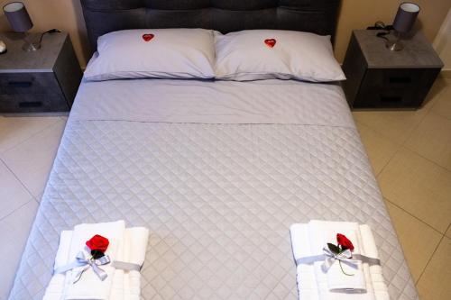 a bed with two towels and red roses on it at ALMI B&B in Sarno
