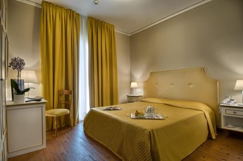 a hotel room with a bed with a yellow bedspread at Hotel Terme Principe in Abano Terme