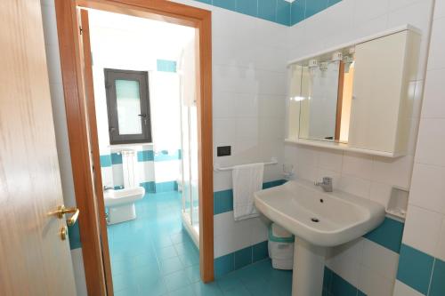 a blue and white bathroom with a sink and a toilet at Miramare Residence in Pozzuoli