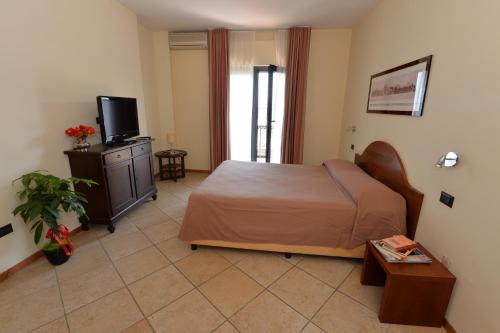 a bedroom with a bed and a television in it at Miramare Residence in Pozzuoli