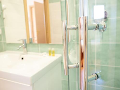 a bathroom with a shower with a sink and a mirror at Casale Del Borgo in San Severino