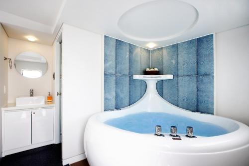 uma casa de banho com uma grande banheira no meio em Tropical Dream Spa Caravan em Geoje