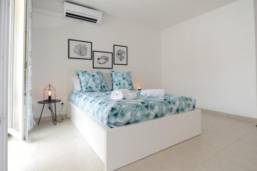 Cette chambre blanche dispose d'un lit avec une couverture bleue. dans l'établissement Mini suite Othello - Five Stars Holiday House, à Nice