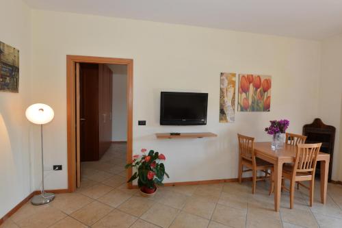 a dining room with a table and a tv on a wall at Miramare Residence in Pozzuoli