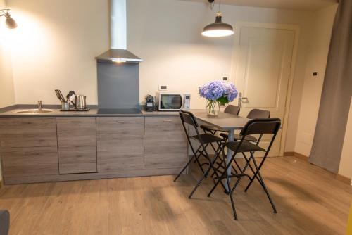 a kitchen with a table with chairs and a microwave at Casa Diverio in Stresa