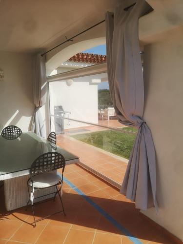 a room with a large window and a table and chairs at Villa Smeralda in Palau