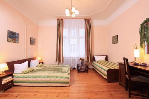 a bedroom with two beds and a desk and a window at Ark am Hauptbahnhof in Berlin