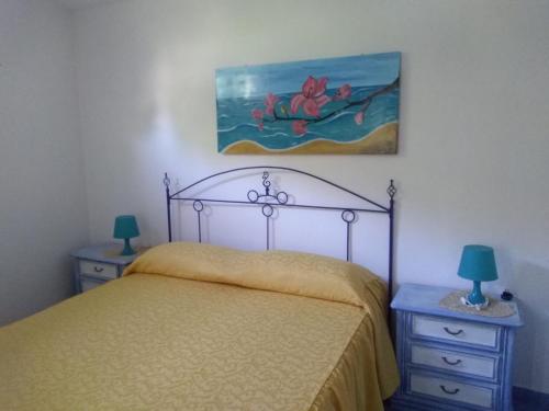 マラテーアにあるTreMetriSopraAlMareのベッドルーム1室(ベッド1台、ナイトスタンド2台、絵画付)