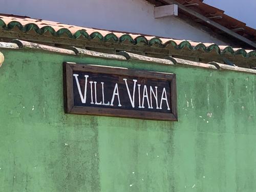 a sign on the side of a green building at Villa Viana in Jericoacoara