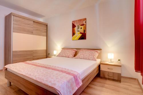 sypialnia z łóżkiem i obrazem na ścianie w obiekcie Holiday Home Mihael w Medulinie