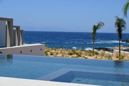 a swimming pool with a view of the ocean at Kavos Hotel & Suites in Stavros