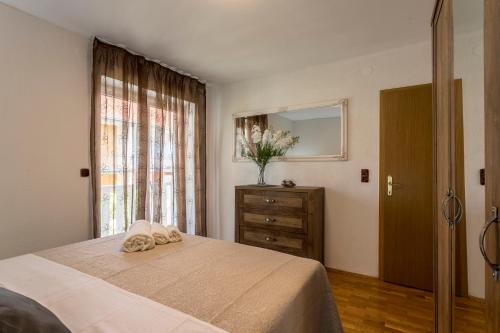 a bedroom with a bed and a dresser and a window at Azzuro in Kaštela