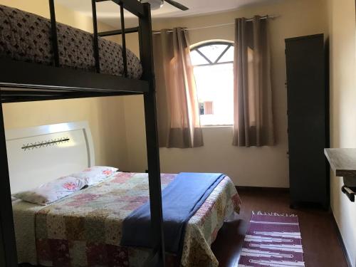 安格拉杜斯雷斯的住宿－Le Monde Hostel - Suites e Camas，一间卧室设有两张双层床和一扇窗户。
