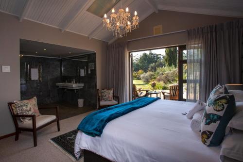 a large bedroom with a large bed and a bathroom at Slaley Country House in Stellenbosch