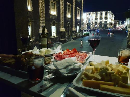 stół z talerzem jedzenia i kieliszkiem wina w obiekcie Duomo Bed & Breakfast w Katanii