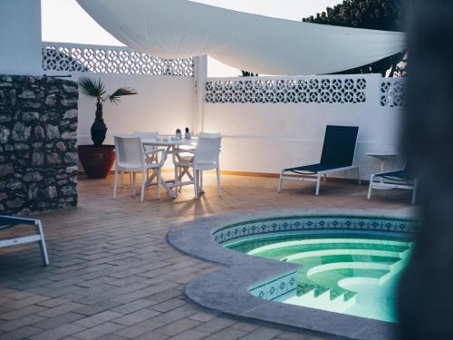 a patio with a table and chairs and a pool at Vivenda Brito in Carvoeiro