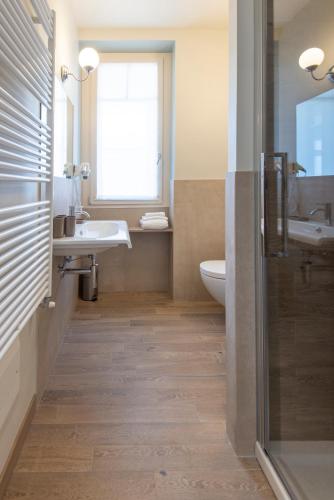 a bathroom with a sink and a toilet and a window at Casa Diverio in Stresa