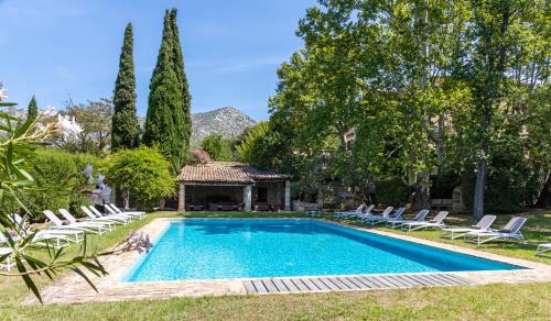 una piscina en un patio con sillas y cenador en La Magdeleine - Mathias Dandine, en Gémenos