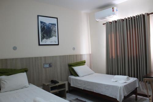 a hospital room with two beds and a window at Limeira Plaza Hotel in Limeira