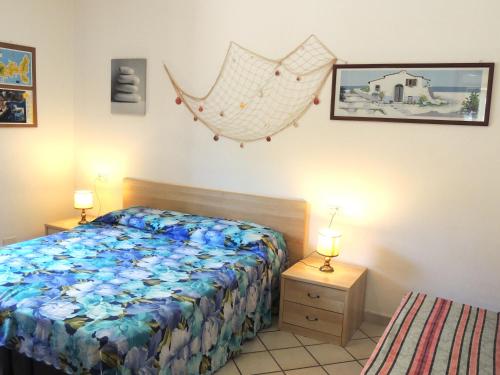 a bedroom with a bed and two night stands and two lamps at Appartamenti Montecristo e Pianosa in Seccheto