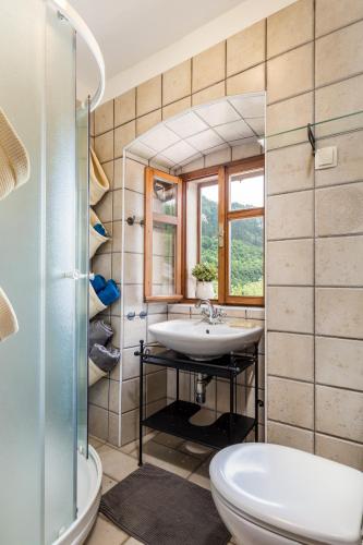 a bathroom with a sink and a toilet and a window at House Pavincic in Lovran
