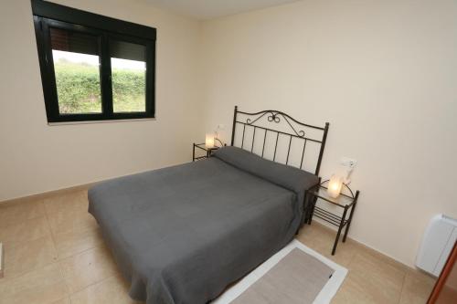 1 dormitorio con cama y ventana en viviendas de uso turístico FINISTERRAE PLAYA, en Finisterre