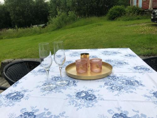 a table with two wine glasses and a plate on it at Auregarden - a rustique oasis just a blink away from town centre in Vik