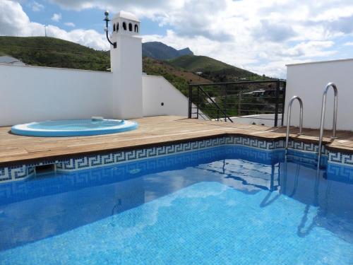 a large swimming pool with a wooden deck next to a building at Apartamentos Ardales Premium in Ardales