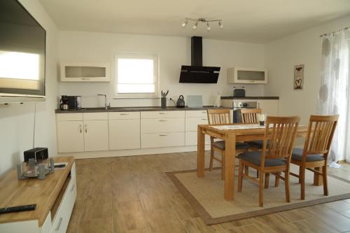 cocina con mesa de madera y sillas en Riethelblick, en Volkesfeld