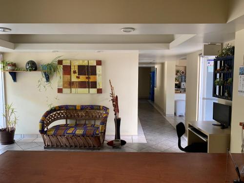 a living room with a couch and a tv at Hotel Posada Don Fernando in Ensenada