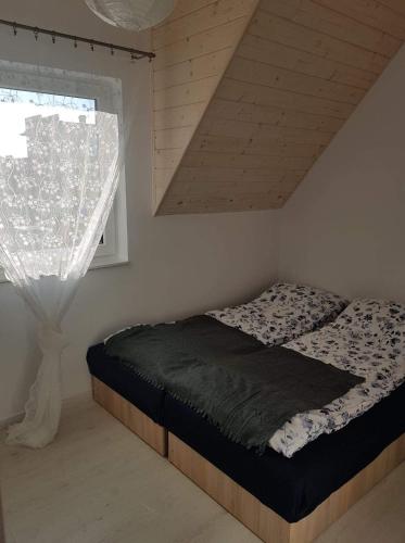 a bedroom with a bed and a window with a curtain at DOMKI "apartamenty 4maki" in Jastrzębia Góra