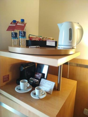 a shelf with two cups and a coffee maker on it at Maran Suites & Towers in Paraná