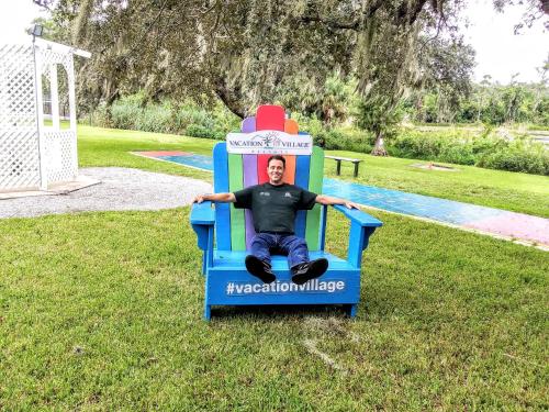 a boy sitting on a bench in a park at Grand Lake & Lifetime of Vacations Resorts in Orlando