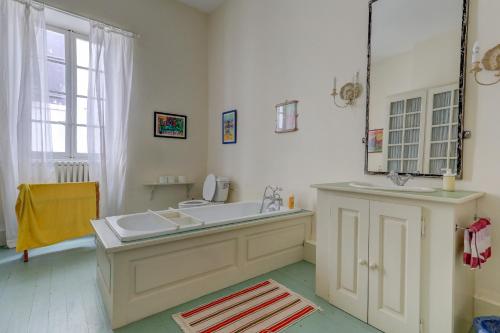 une salle de bain avec un lavabo et un miroir dans l'établissement Les chambres Anglaises, à Largentière
