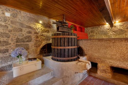 een kamer met een stenen muur en een houten plafond bij Casa do Eido - sustainable living & nature experiences Gerês in Geres