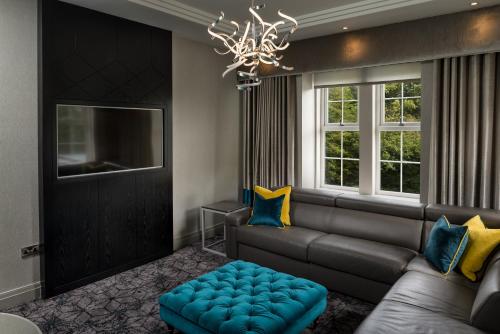 a living room with a couch and a chandelier at Dalmeny Park House Hotel in Barrhead