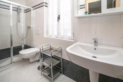 ein Badezimmer mit Waschbecken, Toilette und Dusche in der Unterkunft Hotel Del Mera in Sorico