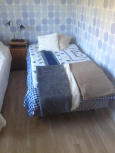 a bedroom with a bed with a blue and white comforter at Långesjö lillstuga in Fjällbacka
