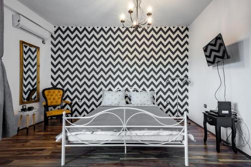 um quarto com uma cama e uma parede xadrez em preto e branco em Urban Chic em Novi Sad