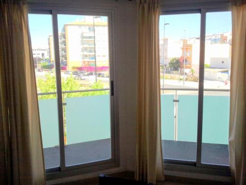Habitación con 2 ventanas y vistas a la piscina. en Apartamento Angeles - Playa de Gandia, en Gandía
