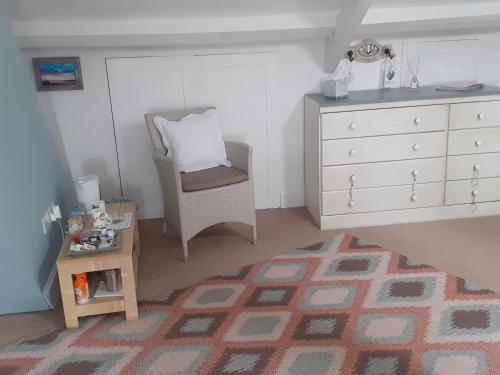 a bedroom with a dresser and a chair and a table at The Bridges B&B in Broomhill
